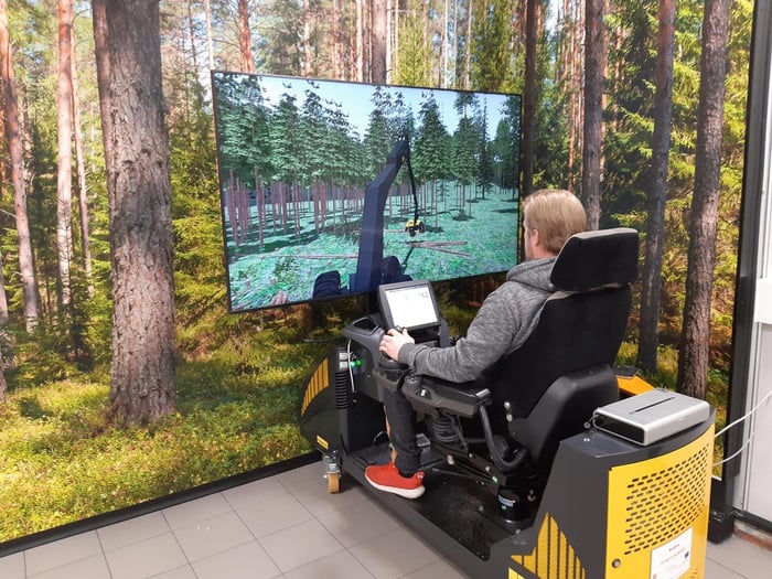 Metsäalan opiskelija simulaattorin ääressä. Metsäalan opiskelija simulaattorin ääressä.