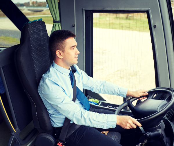 Linja-autonkuljettaja istuimellaan linja-autossa ohjaamassa. Linja-autonkuljettaja istuimellaan linja-autossa ohjaamassa.