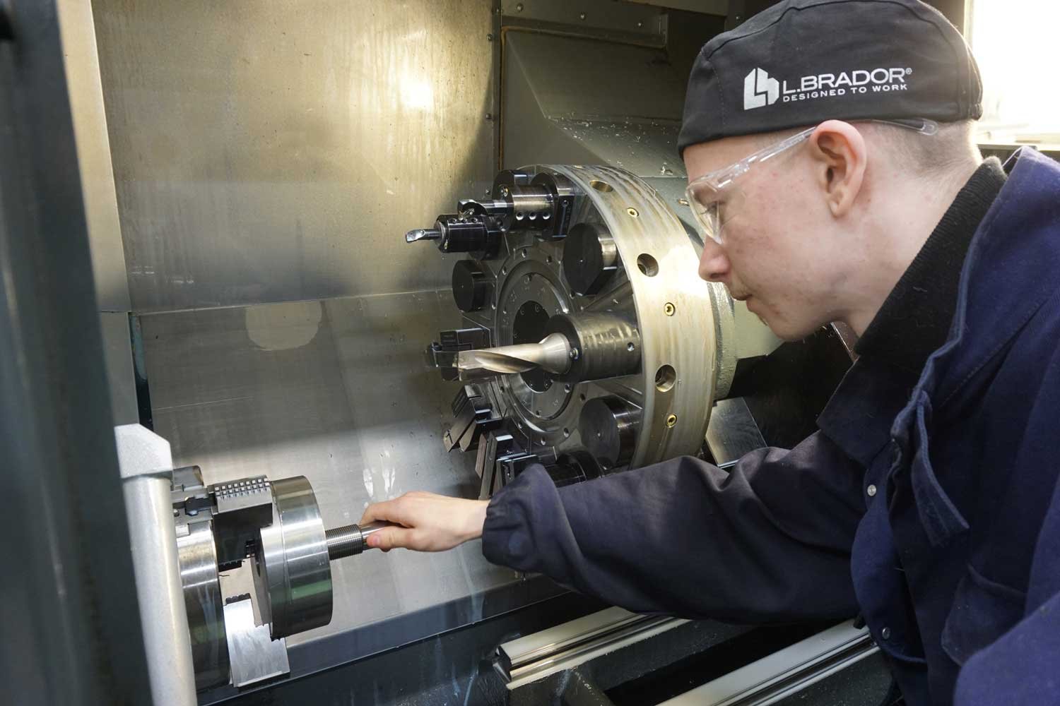 Koneistaja CNC-sorvauskoneen äärellä. Koneistaja CNC-sorvauskoneen äärellä.